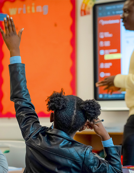 Child raising a hand during a GLC children's ministry session