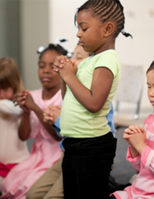 Children praying together during Surge at GLC London